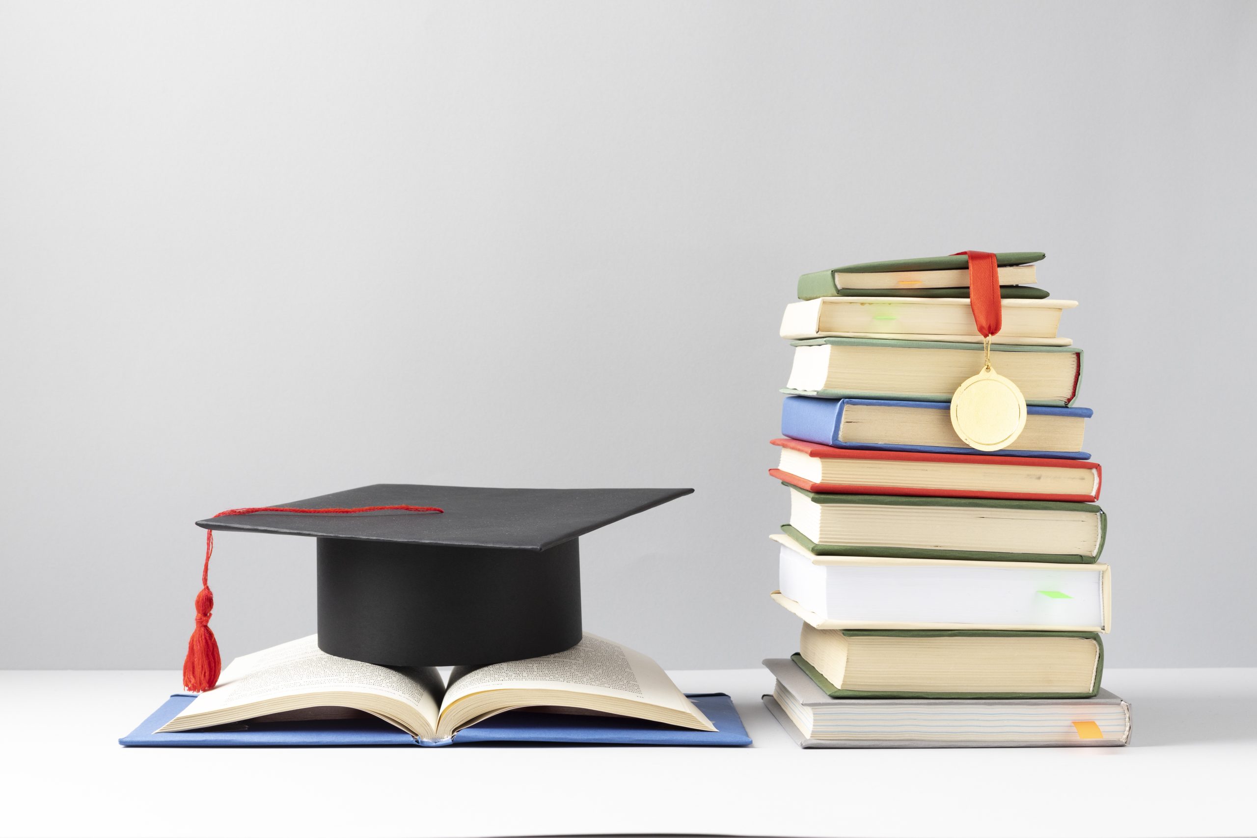 front-view-stacked-books-graduation-cap-open-book-education-day